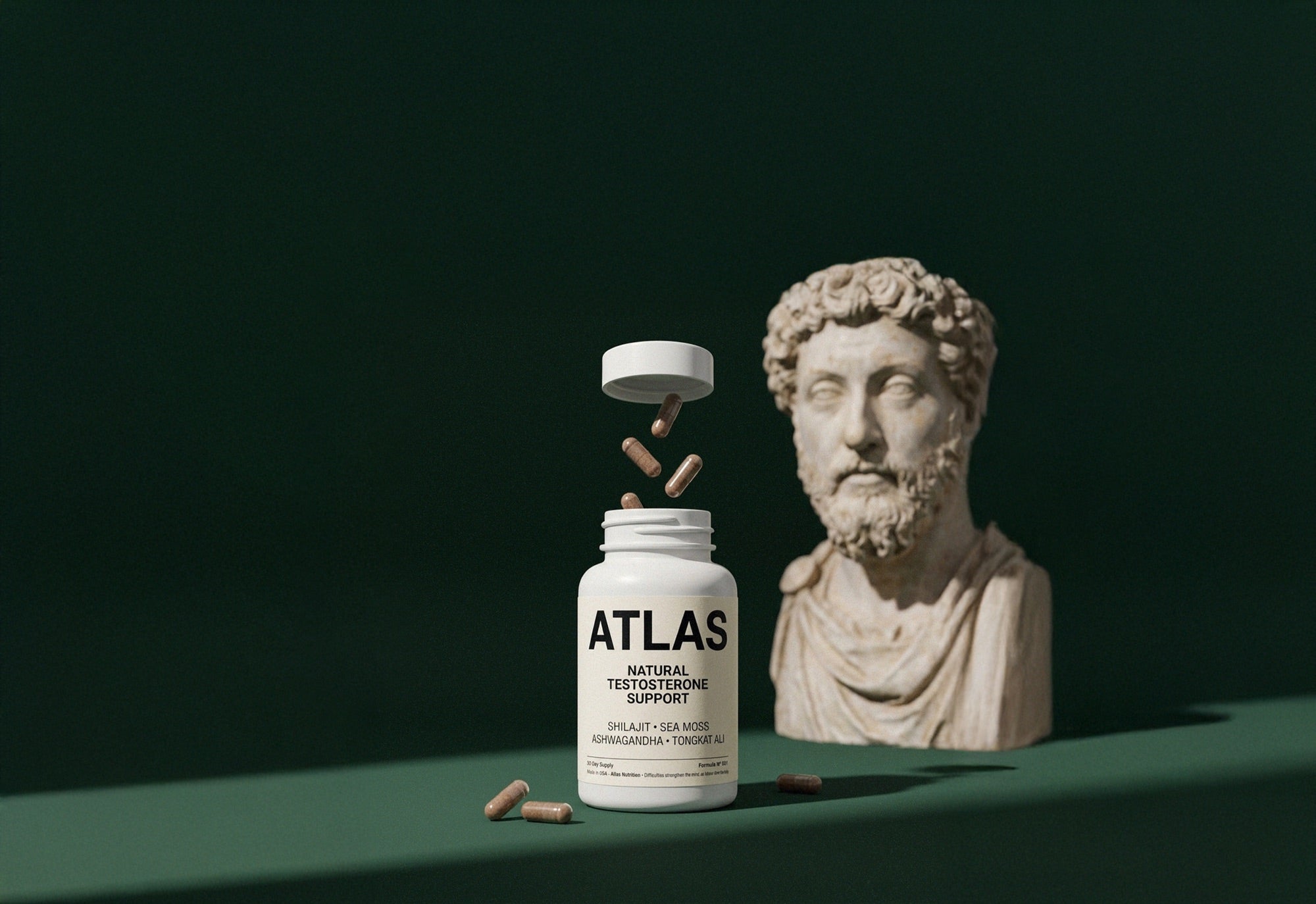 Atlas bottle, capsules and a Marcus Aurelius bust on emerald